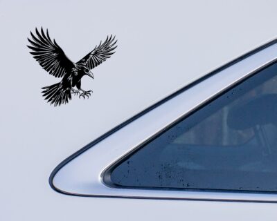 Striking black silhouette vinyl decal of a raven in mid-flight, wings spread wide and talons extended.