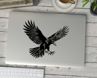 Striking black silhouette vinyl decal of a raven in mid-flight, wings spread wide and talons extended.