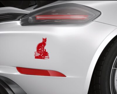 Vinyl decal of a cat sitting gracefully on a stack of books, rendered in a bold silhouette style.