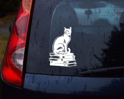 Vinyl decal of a cat sitting gracefully on a stack of books, rendered in a bold silhouette style.